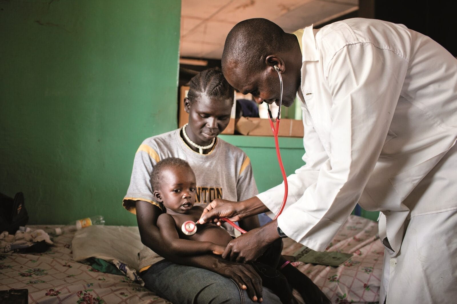 Una mamma e suo figlio ricevono la visita di un operatore di Amref